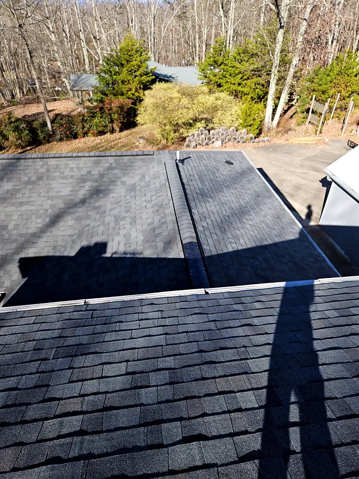 Finished dark gray shingle roof seen from the ridge, wooded yard below, Kings Mountain NC